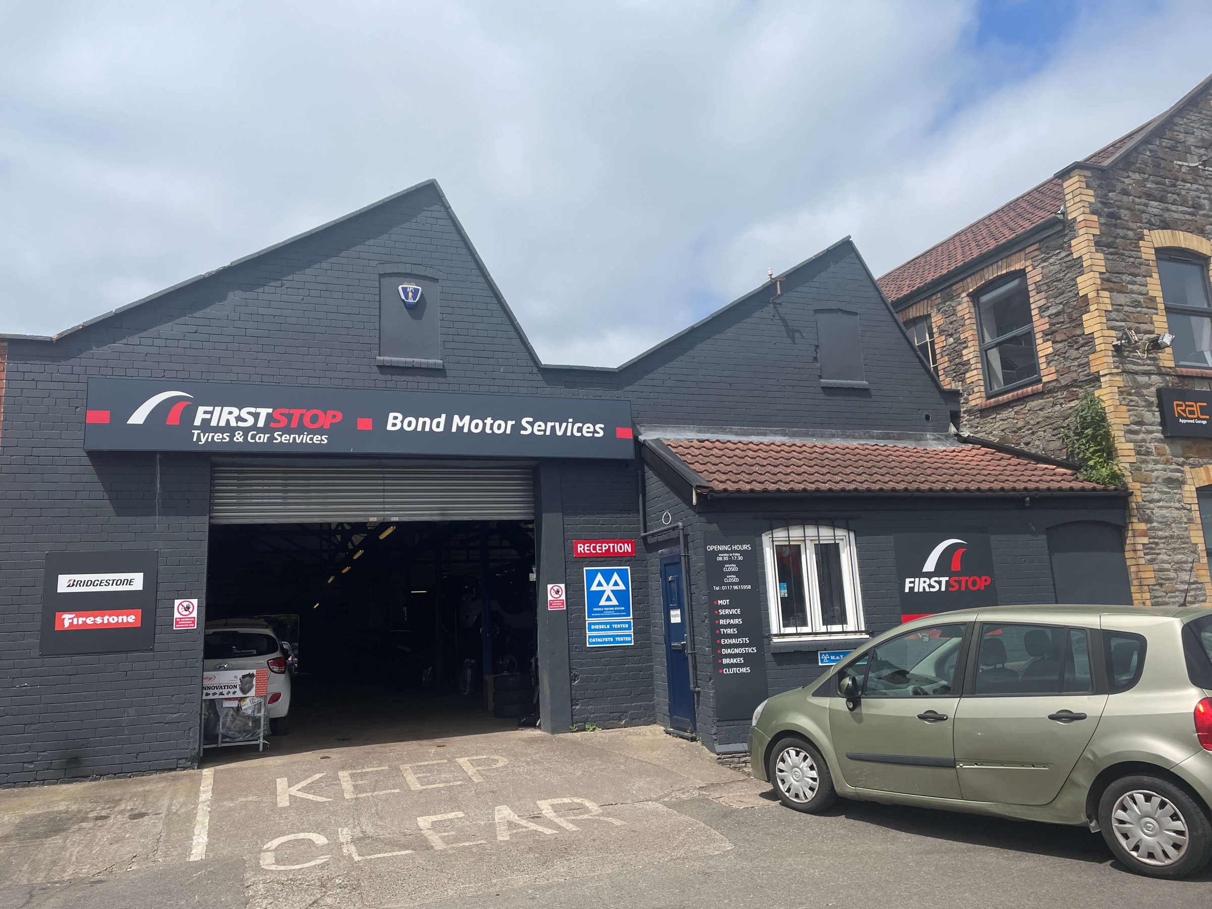 Bond Motor Services on Kingswood High Street: charcoal brick workshop with the roller door open and the reception door beside it